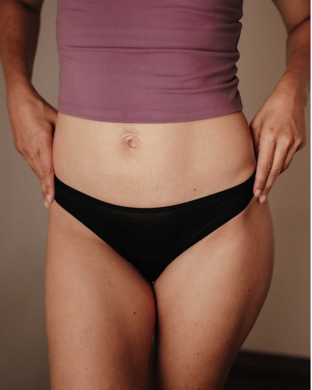 Frontalansicht einer Frau mit dem Everyday DORIS Slip Strong aus feiner Eyelash Lace Spitze. Die edle italienische Spitze zeigt ein zartes, florales Muster und verleiht dem Slip eine elegante, feminine Ausstrahlung. Die leicht erhöhte Leibhöhe formt eine natürliche Silhouette, während der weiche Frottee-Zwickel den ganzen Tag über Komfort bietet. Nachhaltig gefertigt in Portugal aus recycelter Spitze, vegan und hautfreundlich.