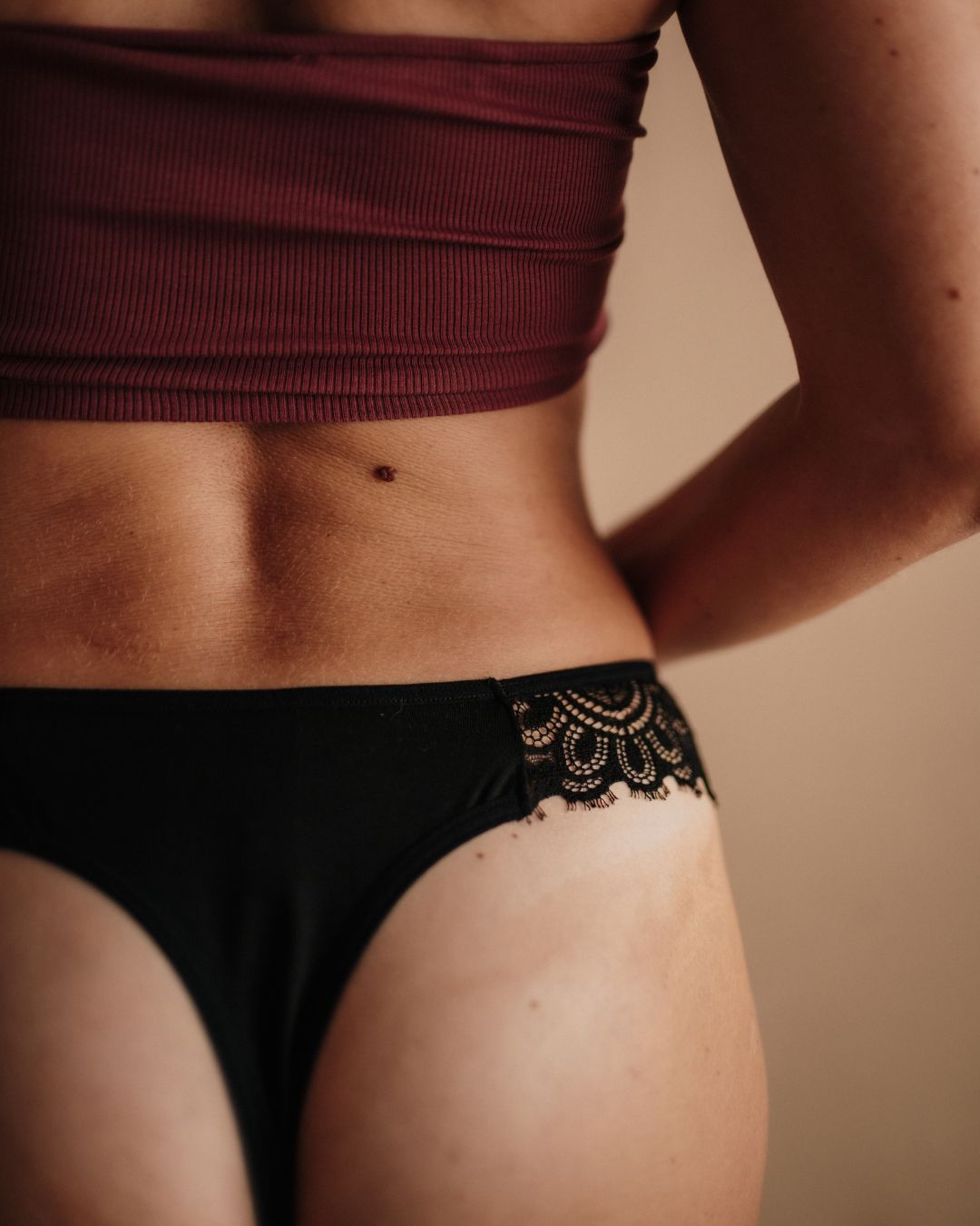 Perioden-String im Detail: Nahaufnahme der eleganten schwarzen Spitze am Bund.