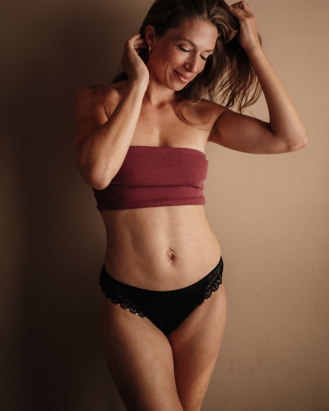 Perioden-Tanga in Schwarz: Frontalansicht mit edlen Spitzen-Details, fair produziert in der EU