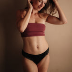 Perioden-Tanga in Schwarz: Frontalansicht mit edlen Spitzen-Details, fair produziert in der EU