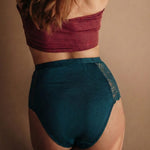 Rückansicht der High Waist Perioden-Panty in Emerald Grün. Zeigt den bequemen hohen Bund und die mittlere Gesäßabdeckung in edler grüner Optik.