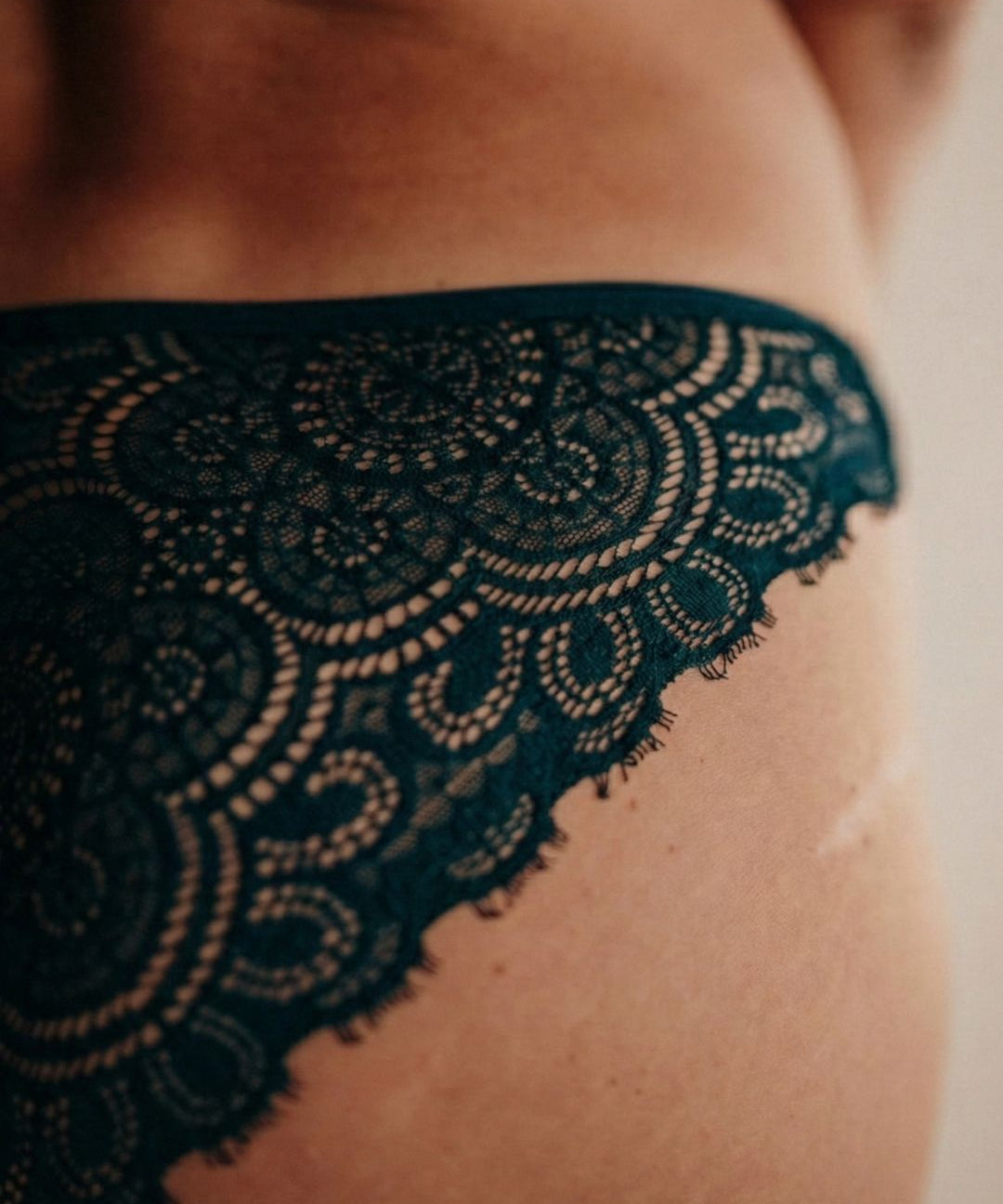 Close up Frau trägt Periodenunterwäsche in Saugstärke 3 aus Spitze und Tencel Micromodal in der Farbe emerald grün