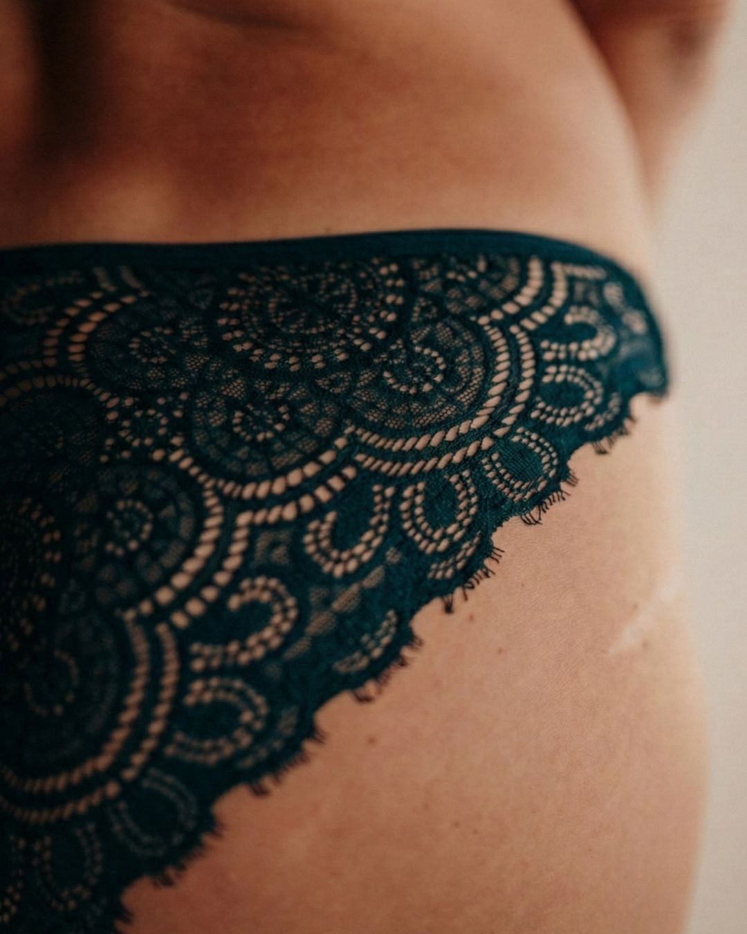 Close up Frau trägt Periodenunterwäsche in Saugstärke 3 aus Spitze und Tencel Micromodal in der Farbe emerald grün