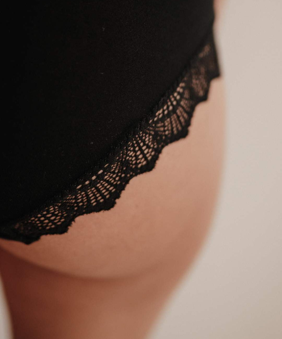 Makroaufnahme der Spitze am Bund der Perioden-Panty. Die Spitze ist fein, weich und wird aus recycelten Fasern in Italien gefertigt. Sie verleiht der Periodenunterwäsche ein feminines Detail, das Eleganz und Nachhaltigkeit verbindet. Trotz der feinen Optik ist die Spitze strapazierfähig und langlebig.