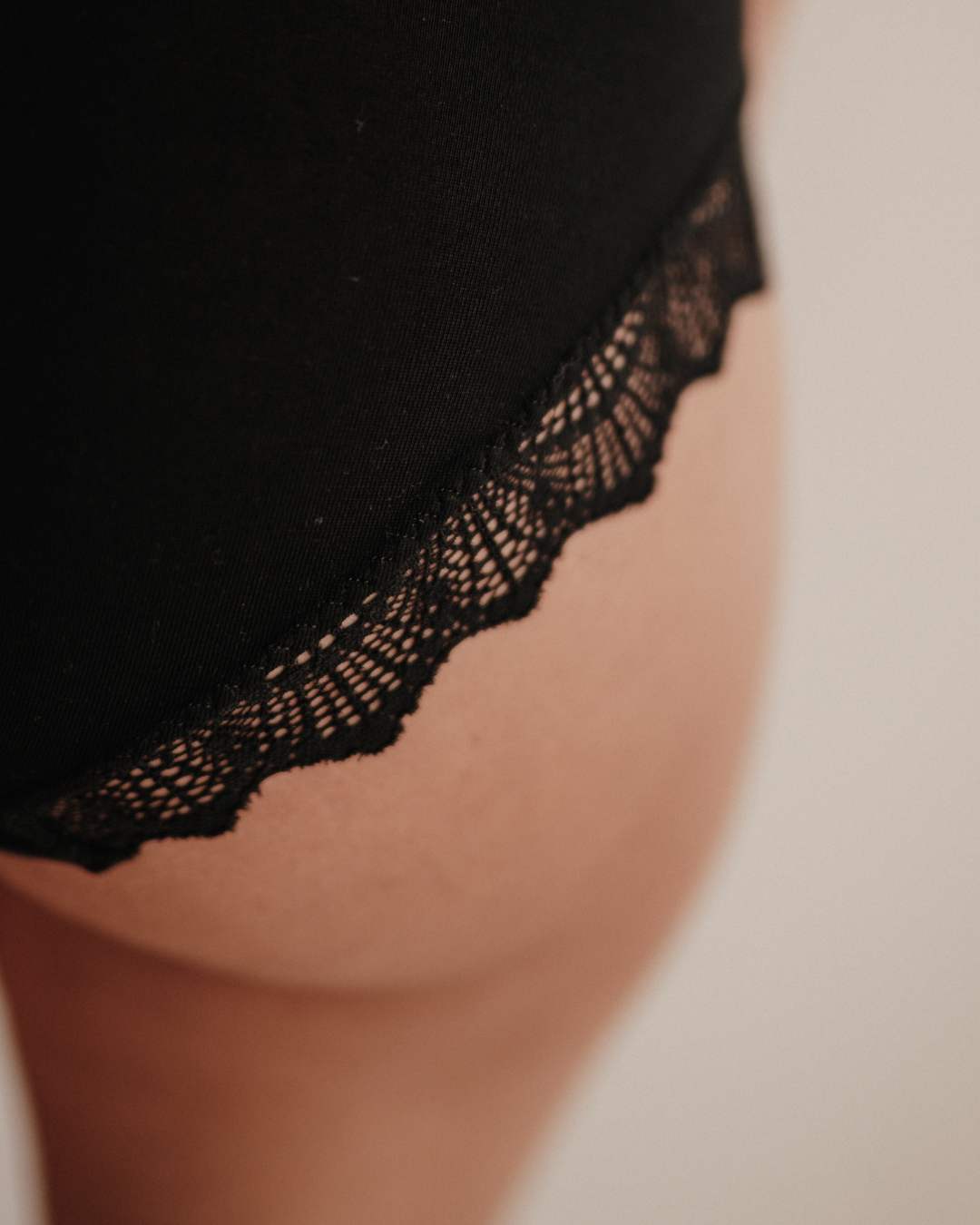 Makroaufnahme der Spitze am Bund der Perioden-Panty. Die Spitze ist fein, weich und wird aus recycelten Fasern in Italien gefertigt. Sie verleiht der Periodenunterwäsche ein feminines Detail, das Eleganz und Nachhaltigkeit verbindet. Trotz der feinen Optik ist die Spitze strapazierfähig und langlebig.