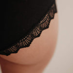 Makroaufnahme der Spitze am Bund der Perioden-Panty. Die Spitze ist fein, weich und wird aus recycelten Fasern in Italien gefertigt. Sie verleiht der Periodenunterwäsche ein feminines Detail, das Eleganz und Nachhaltigkeit verbindet. Trotz der feinen Optik ist die Spitze strapazierfähig und langlebig.