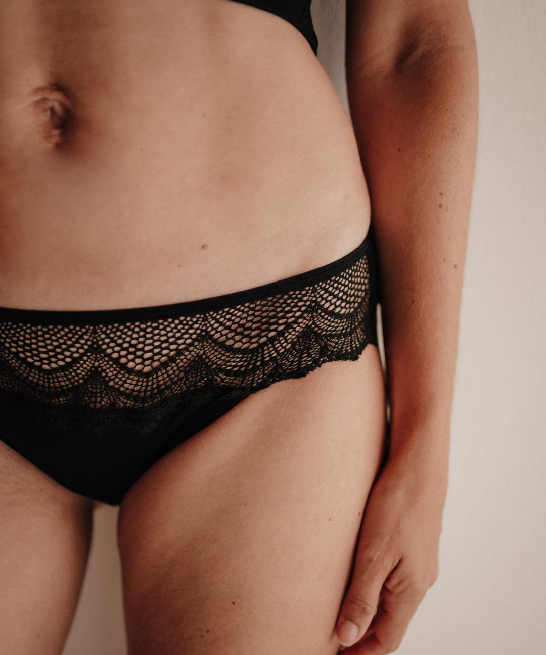 Nahaufnahme der Vorderseite einer Periodenunterwäsche im Hipster-Schnitt: extra hohe Sauglage für Frontbleeder, Smart Layer Technologie, feine Spitze aus recycelten Fasern.