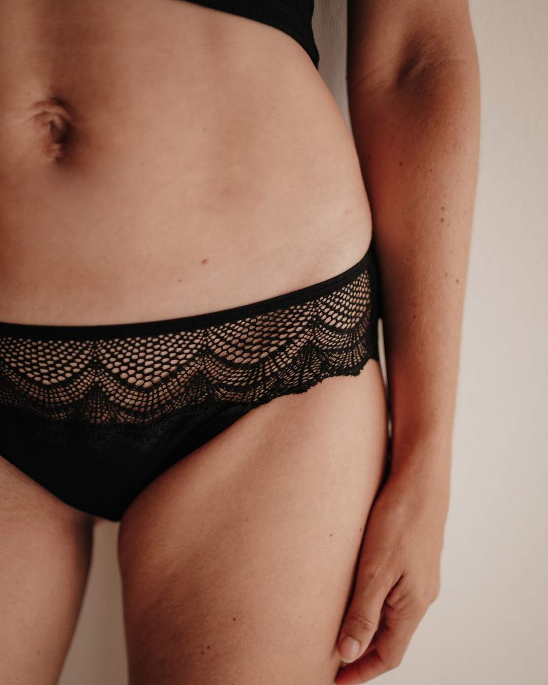 Nahaufnahme der Vorderseite einer Periodenunterwäsche im Hipster-Schnitt: extra hohe Sauglage für Frontbleeder, Smart Layer Technologie, feine Spitze aus recycelten Fasern.
