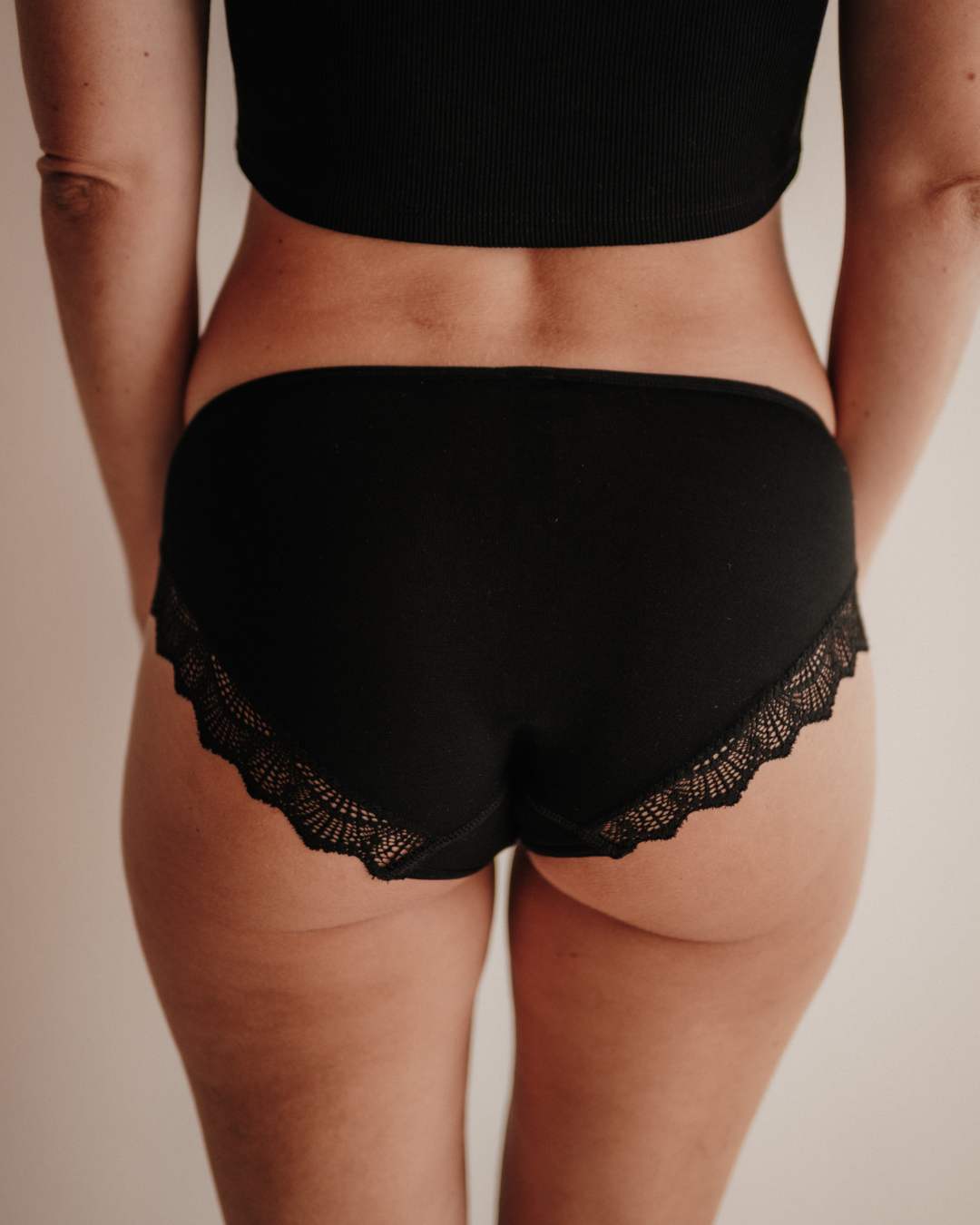 Detailaufnahme der Rückseite der Hipster-Periodenunterwäsche. Die Panty schmiegt sich eng an und bietet dank der Smart Layer Technologie maximale Sicherheit ohne Auslaufen. Der Stoff bleibt auch bei Bewegung an Ort und Stelle und verhindert ein unangenehmes Windelgefühl. Die nachhaltige Spitze aus Italien rundet das hochwertige Design ab.
