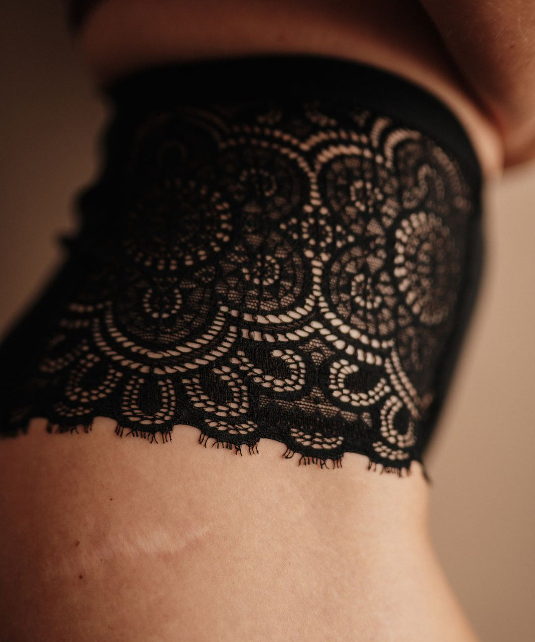 Seitenansicht der High Waist Periodenunterwäsche in Schwarz. Zeitloses Design mit hohem Beinausschnitt und Spitzeneinsatz für maximalen Komfort während der Periode.